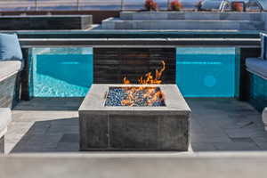 View of swimming pool featuring a patio area and a fire pit