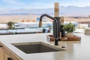 Interior details with light brown cabinetry, light countertops, a sink, and a mountain view