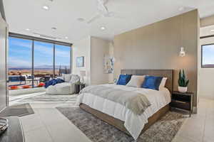 Bedroom with light tile patterned floors, multiple windows, and a mountain view