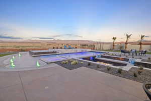 Pool at dusk with a mountain view, an outdoor pool, and a patio