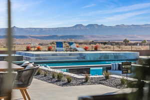 View of swimming pool featuring a swimming pool, a patio area, fence, and a mountain view