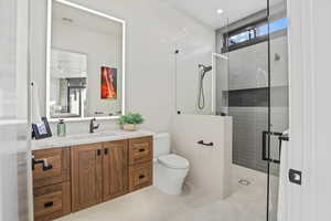 Bathroom with toilet, visible vents, a tile shower, and vanity