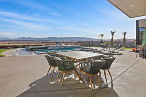 Outdoor pool with outdoor dining area, a patio area, a mountain view, and fence