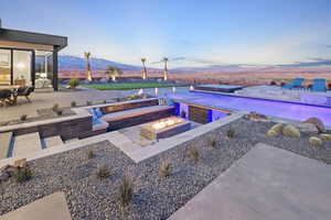 Pool with an outdoor fire pit, a patio area, and a mountain view