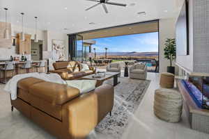 Living area with ceiling fan, expansive windows, a mountain view, and recessed lighting