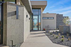 View of exterior entry featuring concrete block siding and stucco siding