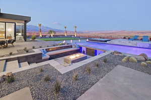 Exterior space featuring an outdoor fire pit, a mountain view, and an outdoor pool