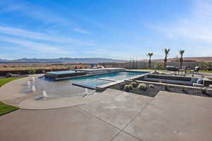 View of swimming pool featuring a fenced in pool, a patio area, a mountain view, fence, and an in ground hot tub