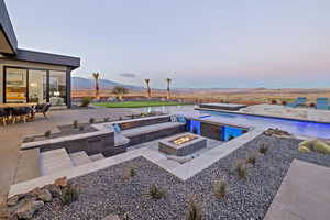 Pool with a patio area, a fire pit, and a mountain view