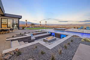 Outdoor pool featuring a fire pit, a patio area, and a mountain view