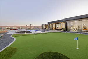 Pool at dusk with a patio area and a pool with connected hot tub