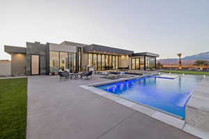 Pool at dusk with a patio, a mountain view, and an outdoor pool