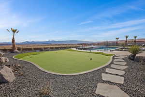 View of home's community with a swimming pool, a mountain view, fence, and a patio