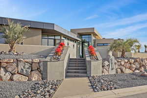 View of front of property featuring stairway and stucco siding