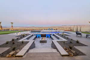 View of pool featuring an outdoor fire pit, a mountain view, and a patio