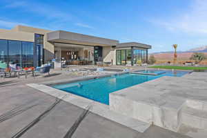 Pool featuring a patio area, a hot tub, and a mountain view