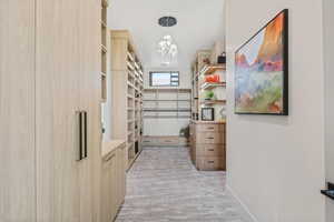 Spacious closet featuring a notable chandelier