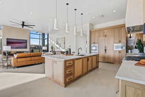 Kitchen featuring a sink, stainless steel oven, open floor plan, a large island, and pendant lighting