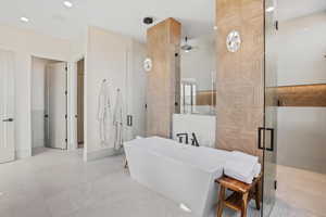 Full bathroom with a stall shower, a freestanding bath, and recessed lighting