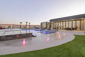 View of pool with an outdoor fire pit, a pool with connected hot tub, and a patio area