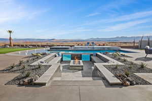 View of swimming pool with an outdoor fire pit, a patio area, and a mountain view