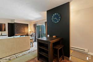 Living room featuring carpet floors, a textured ceiling, and baseboard heating