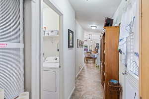 Corridor featuring washer / dryer and baseboards