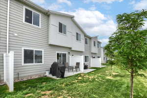 Rear view of property featuring a yard, a patio area, and cooling unit