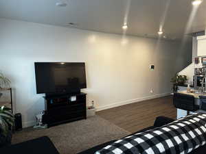 Living area featuring baseboards, visible vents, dark wood-style flooring, and recessed lighting