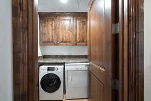 Laundry room featuring washing machine and dryer and cabinet space