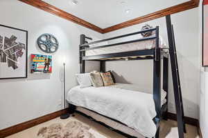 Carpeted bedroom featuring baseboards and crown molding