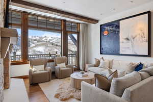 Living room with baseboards, a mountain view, beamed ceiling, and wood finished floors