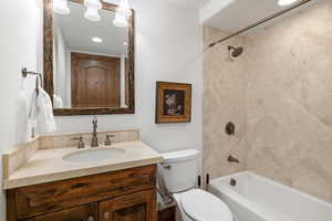 Full bath with shower / bathing tub combination, vanity, and toilet