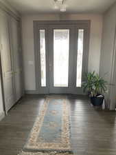 Entryway with plenty of natural light, wood finished floors, and baseboards