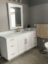 Bathroom featuring toilet, wood finished floors, and vanity