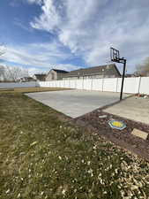 View of patio featuring basketball hoop and fence