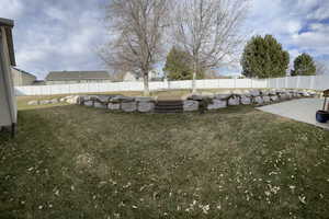 View of yard with a fenced backyard and a patio