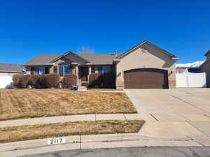 Rambler home with a garage, fence, concrete driveway, a gate, and stucco siding