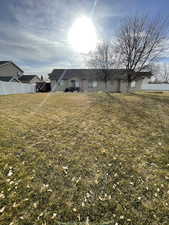 Back of house featuring a yard and fence