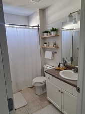 Full bath with visible vents, toilet, tile patterned flooring, a textured ceiling, and vanity