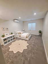 Bedroom featuring carpet, recessed lighting, baseboards, and a wall mounted AC