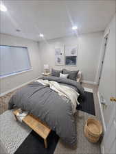 Carpeted bedroom with recessed lighting, visible vents, and baseboards