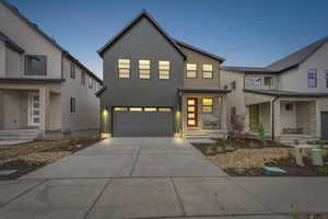 Modern inspired farmhouse featuring concrete driveway and an attached garage