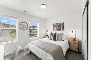 Bedroom with visible vents, dark carpet, baseboards, and multiple windows