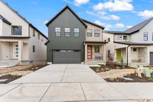 Modern inspired farmhouse featuring a garage and driveway