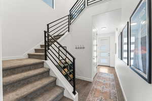 Stairs with wood finished floors and baseboards