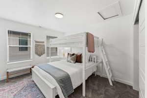 Carpeted bedroom featuring visible vents, attic access, and baseboards