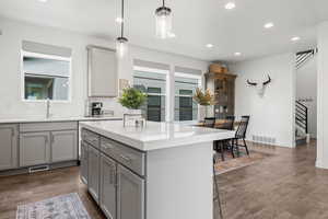 Kitchen with a healthy amount of sunlight, visible vents, a sink, and gray cabinetry