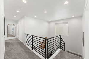 Hall with recessed lighting, baseboards, carpet flooring, and an upstairs landing