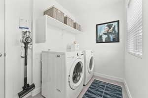 Laundry area featuring laundry area, baseboards, and washing machine and clothes dryer